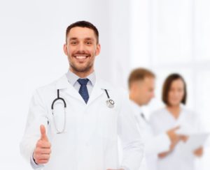 Smiling doctor giving a thumbs-up hand gesture